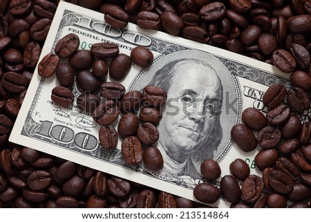 Cost of coffee. One hundred dollar bill and coffee beans. Closeup.