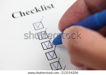 Man\'s hand filling a checklist. Closeup.