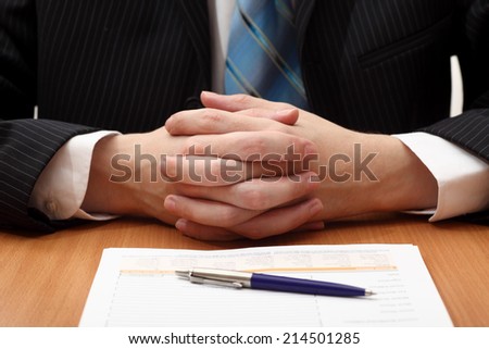 Businessman at work. Businessman sitting at a desk with documents or contract or application form. Closeup.