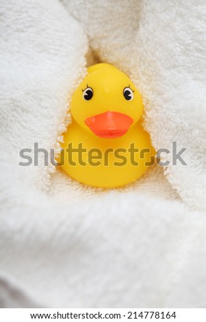 Rubber Duck after bath wrapped in a white soft towel.