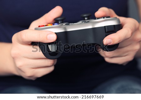 Young woman plays video game using a gamepad. Cross-processing.