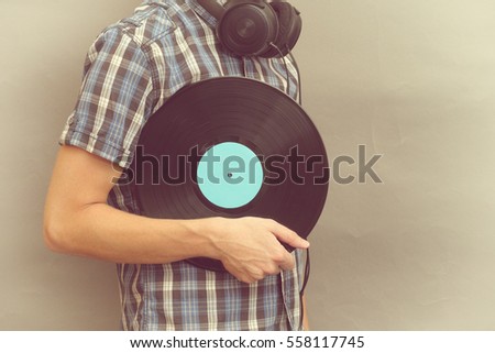 Similar – Image, Stock Photo Man holding vinyl record. Vintage music style. Rock style. Male wearing black jacket holding black disc standing on dark background. Retro music