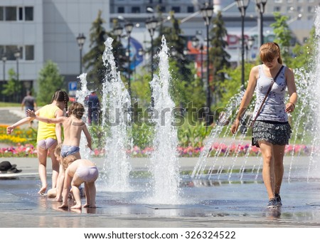 Children bathe in a city fountain on a hot, summer day. Russian Federation. Kemerovo region. Novokuznetsk. 01.07.2015.