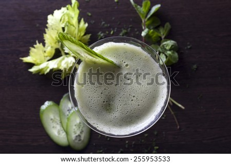 Green juice with apple, cucumber, mint,lettuce, dill and parsley on wooden table.