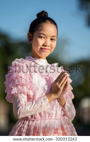 Asian girl wearing a pink antique Thailand.smiling and respect