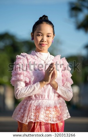 Asian girl wearing a pink antique Thailand.smiling and respect