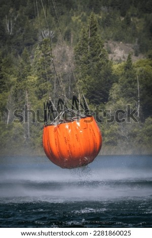 Similar – Image, Stock Photo A firefighting helicopter pours water into a forest to put out a forest fire