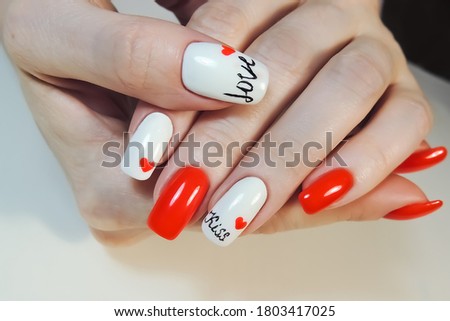 Women's hands on a light background with manicure. Nail coating with white and red gel Polish. Stock foto © 
