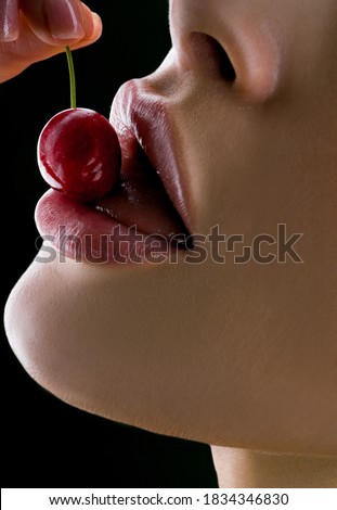 Sexy woman lips. Close up female mouth and sensual lips with secrets. Lips with sweet cherry.. Sweet lips