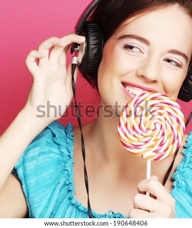 Beautiful woman with headphones and candy