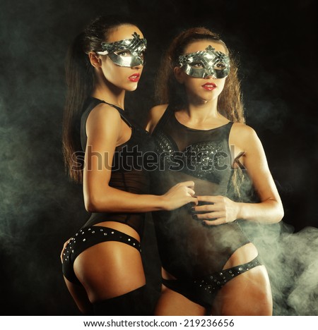 two young sexy striptease dancer with mask, dance in smoke