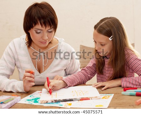 Mom and daughter painting on paper - family