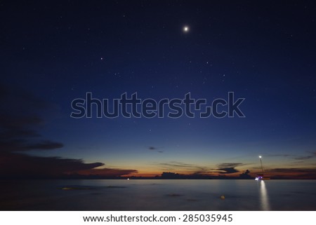 Long exposure shot over the ocean with the stars and a sailing boat from Pualu Tioman beach