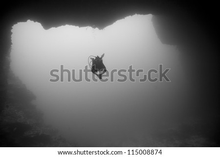 Scuba diver swimming into the Blue Holes Dive Site off the islands of Palau in Micronesia.