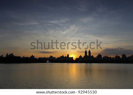 Sunset over buildings of New York City\'s West Side as seen from the Reservoir in Central Park.