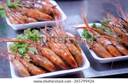 close up detail of the grilled large river prawn serve in white plastic plate in the street food stall in Thailand