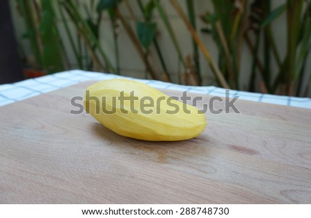 peeled skin yellow mango on timber block