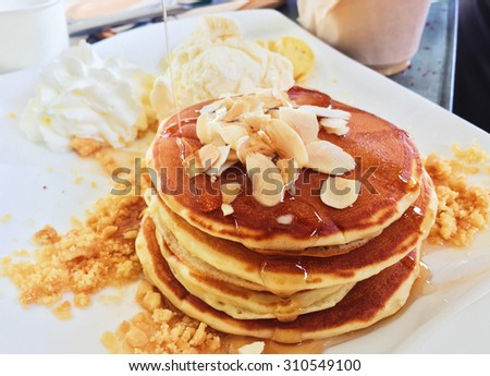Layer of pancakes with almonds and sweet syrup