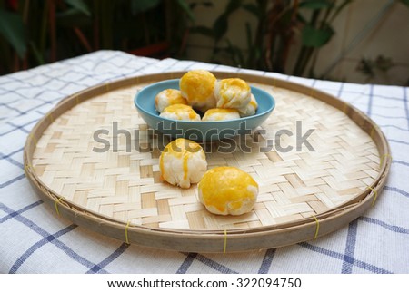 Chinese pastry with salted egg yolk in the blue plate on woven basket