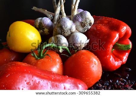 still life of fresh vegetables and dried barberry with drops of water on a dark background
