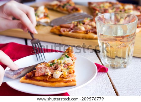 process of eating pizza with sausage, chicken, corn and cheese