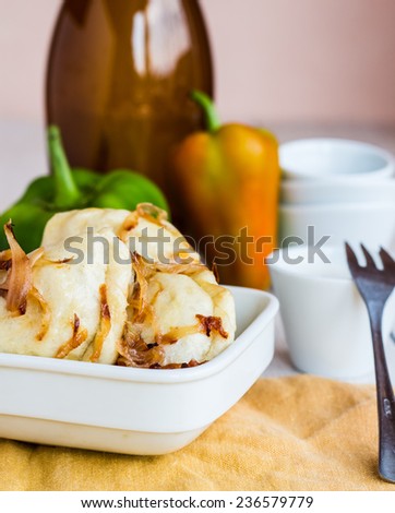 dumplings with fried onions and sour cream, Ukrainian cuisine on a white background