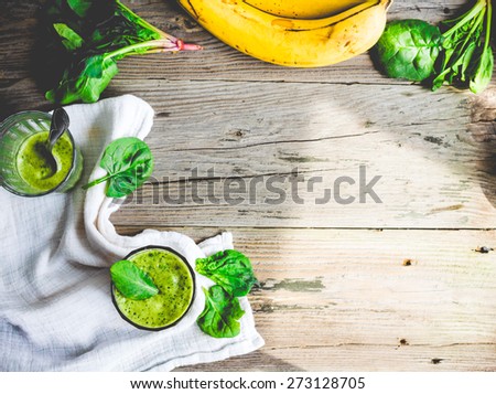 Vitamin green smoothie with spinach leaves, banana, clean eating, on gray background, top view, text