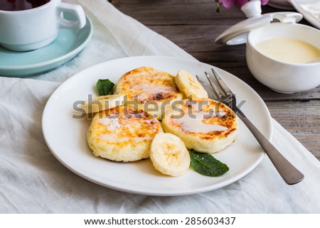 curd cheese pancakes with banana, condensed milk and fresh mint, a cup of tea, a children\'s breakfast