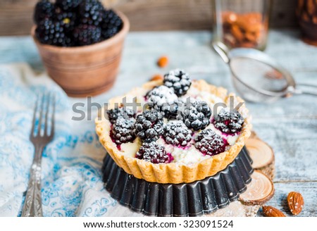 tartlet with cream cheese and blackberry, dessert cheesecake, rustic background,on a light wooden table