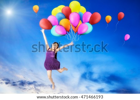 Girl With Colorful Balloons Jumping And The Blue Sky Stock Photo ...