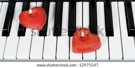 Piano keys with two heart-shaped candles