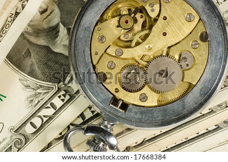 Old watch mechanism and dollar bills (time is money concept)