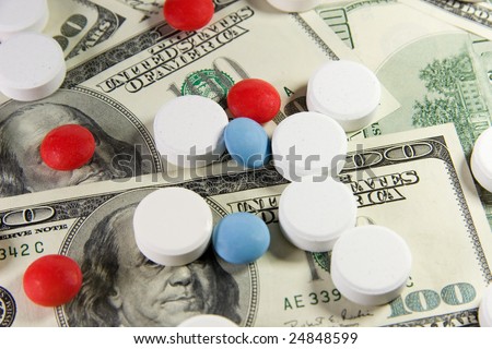 Closeup of white, red and blue pills on a bunch of US dollars
