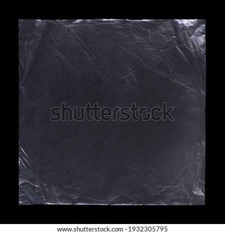 Transparent plastic wrap on the black background. Clean blank texture overlay effect template. Isolated wrinkle surface branding mock-up. Black pack packaging bag.