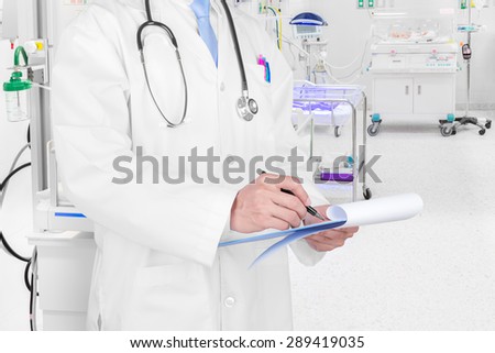 Doctor writing a medical prescription in delivery room