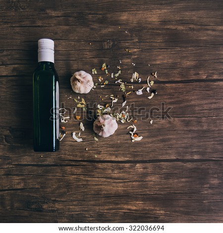 Olive oil and garlic\
A bottle of olive oil and 2 cloves of garlic on an old wooden table