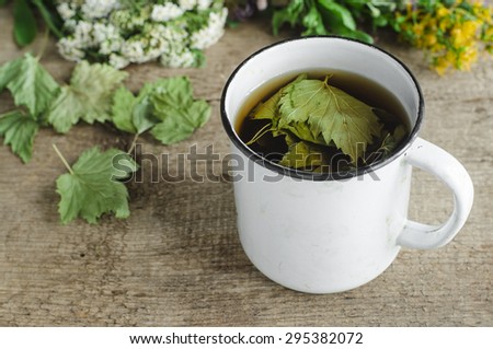 A mug of herbal tea with black currant leaves