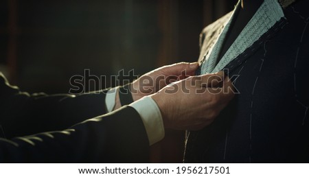 Cinematic shot of professional tailor taking measurements for creation of custom high quality tailored suit in luxury tailoring atelier.Concept of fashion, handmade, hand craft, couturier and business Stock foto © 