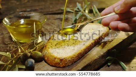 Genuine Italian organic oil cold pressed in slow motion falls on organic bread. concept of nature and healthy food, healthy and natural. fresh olives and Tuscan Italian oil ストックフォト © 