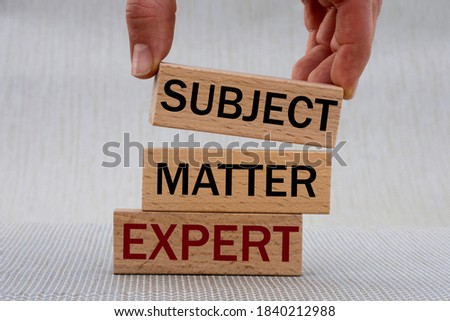 Women's hand folds wooden bars with words SUBJECT, MATTER, EXPERT. Business concept Foto stock © 
