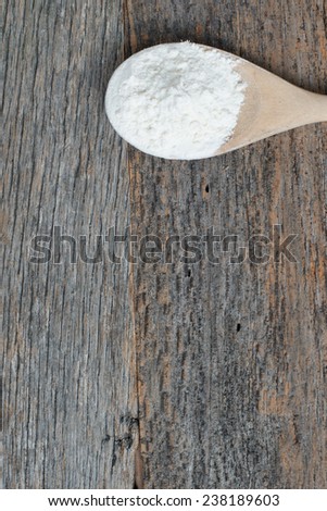 Wooden Spoon Full of Flour on Wooden Background