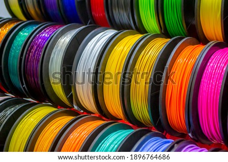 Multicolored filaments of plastic for printing on 3D printer close-up. Spools of 3D printing motley different colors thermoplastic filament. Motley ABS wire plastic for 3d printer. Additive technology Foto stock © 