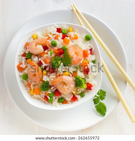 Rice with vegetables and shrimps on white background, top view, square image