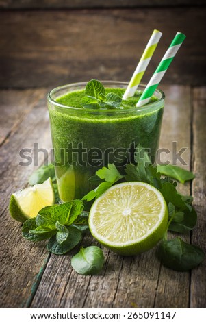 fresh green smoothie with ingredients on rustic background