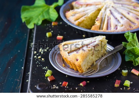 Piece of Rhubarb cake on dark rustic background
