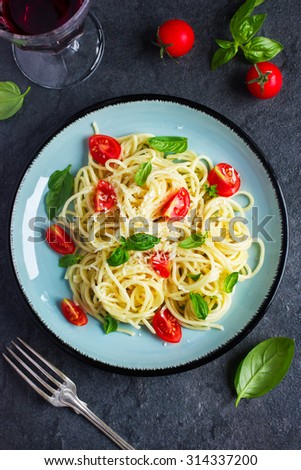 Spaghetti pasta  with cherry tomatoes,  basil and parmesan cheese, top view
