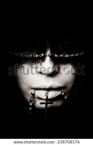 Portrait of a Girl With Black and White Make-Up on a Black Background, With The Cross in Her Mouth. Photo, Picture