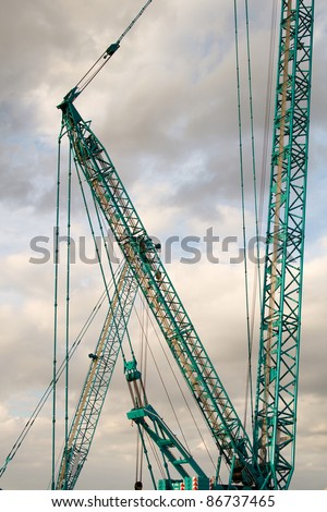 Part of a huge mobile crane on the background of the cloudy sky