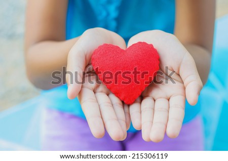 red heart on hand little girl