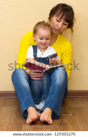 Positive young family reading a book on the floor